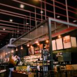 Warm and inviting café interior with modern lighting and seating. Perfect for a relaxing coffee break.